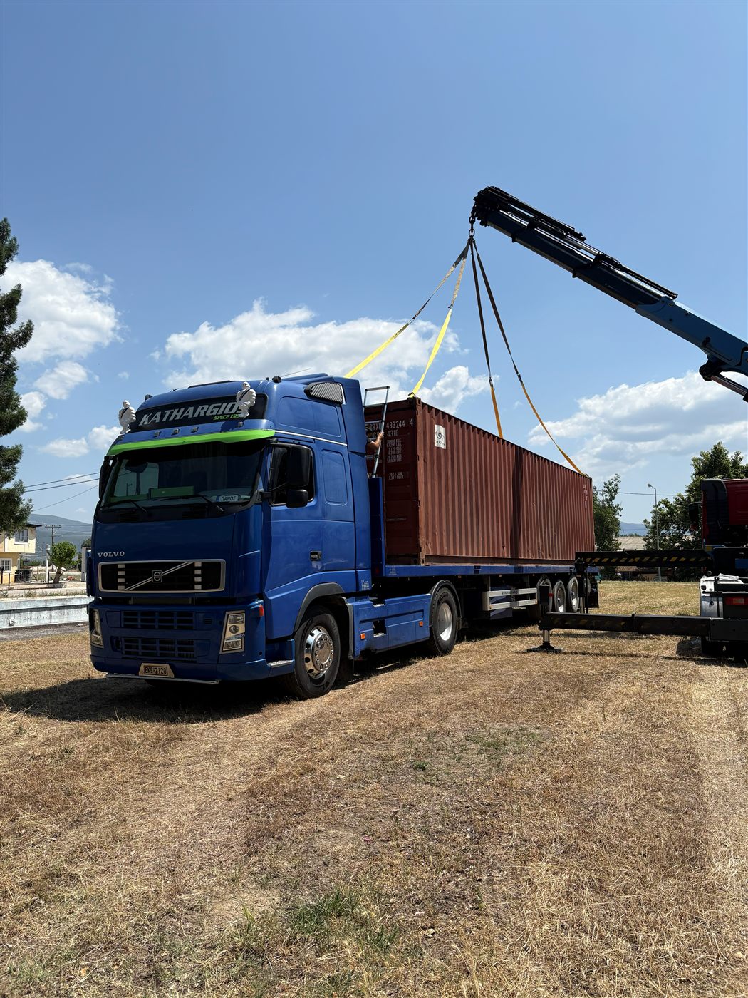 Εθνικές μεταφορές Μπλε φορτηγό Volvo Kathargios Group φορτώνεται με container